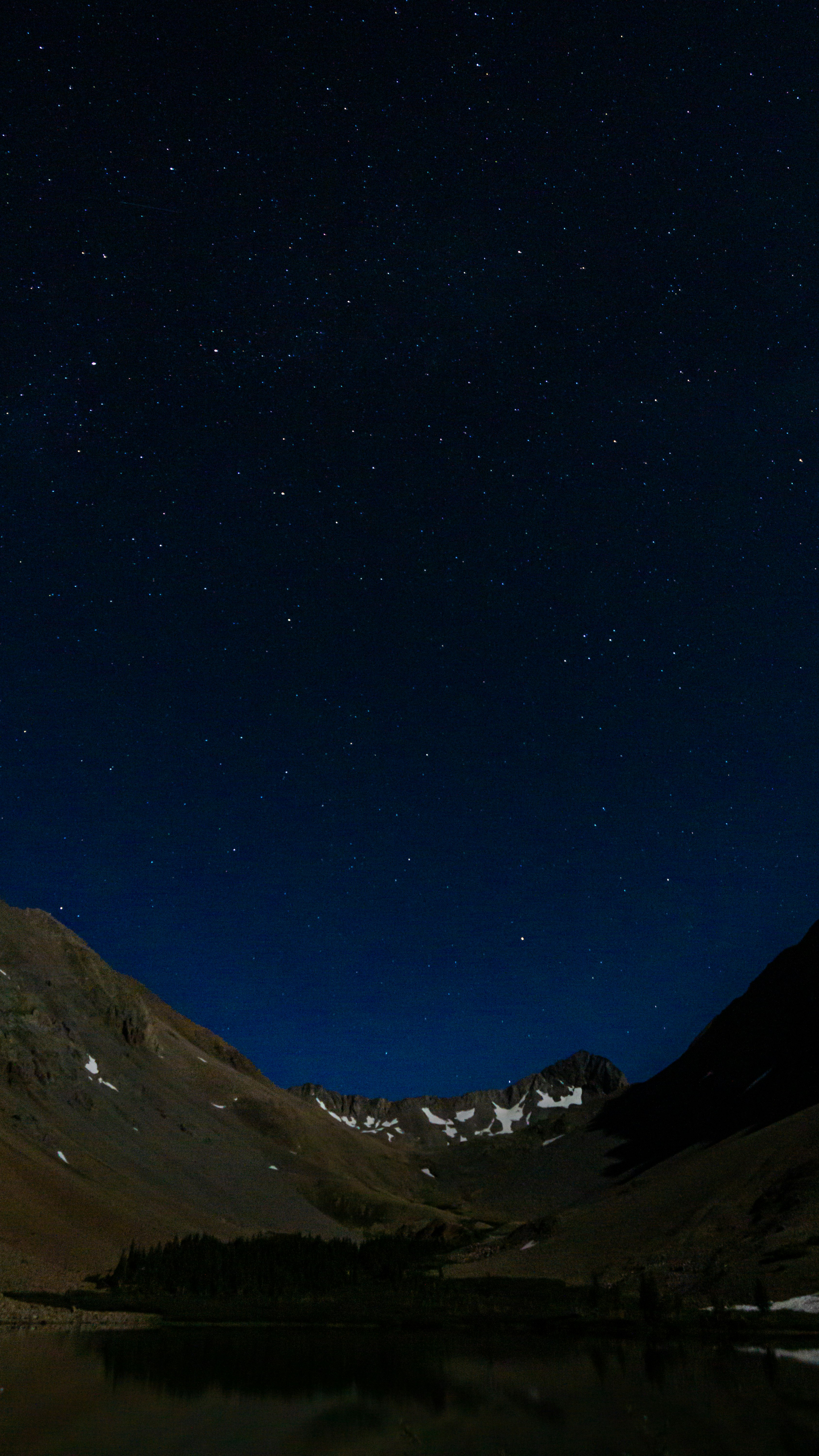 brown and green mountains under blue sky during night time